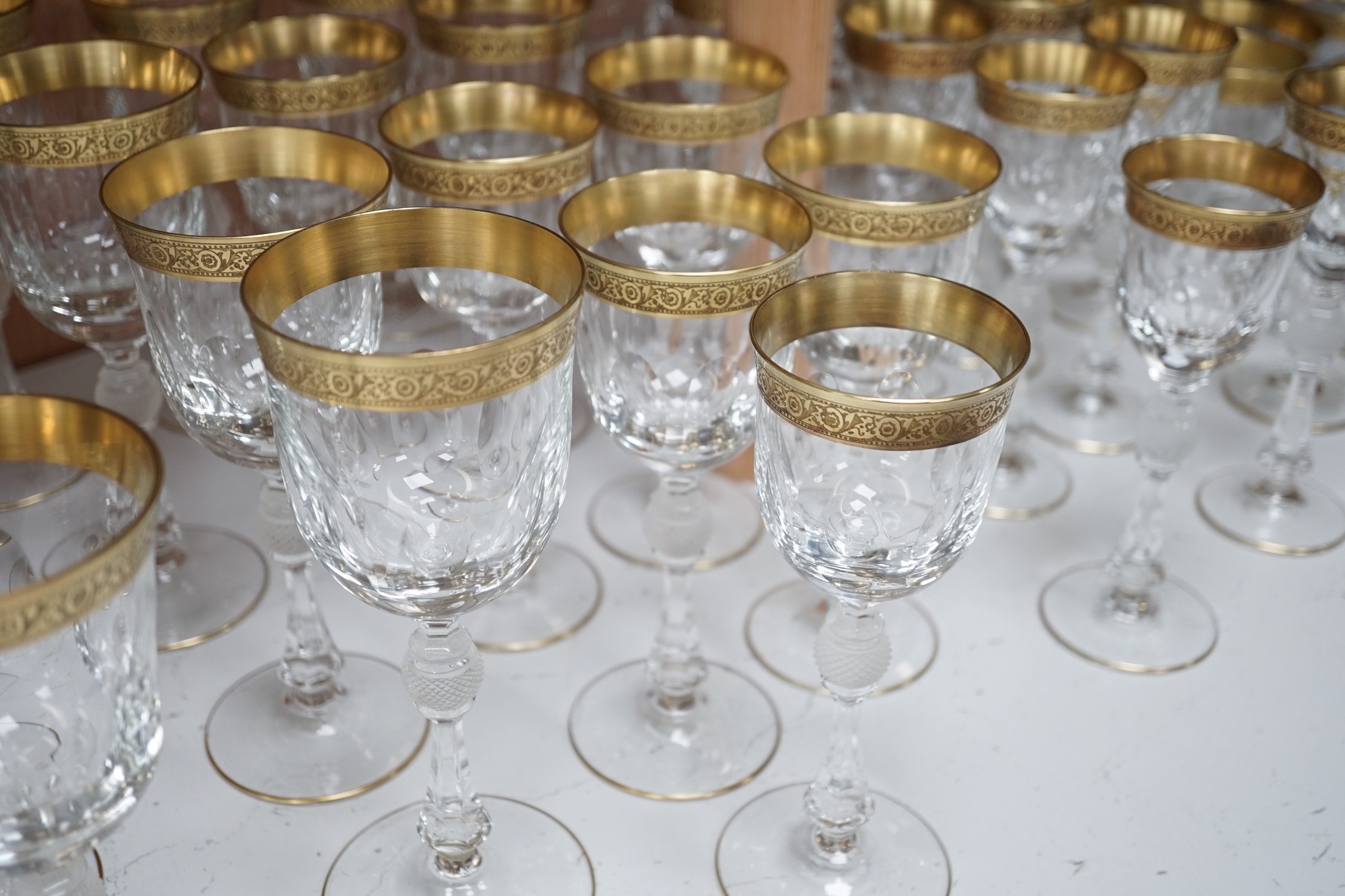 A Harrods retailed parcel gilt and cut and moulded suite of drinking glasses, two decanters and two carafes